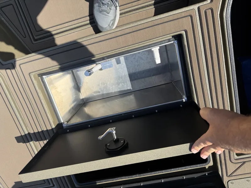 Slide: The Image of An open storage compartment on a boat with a hand holding the lid. - 5