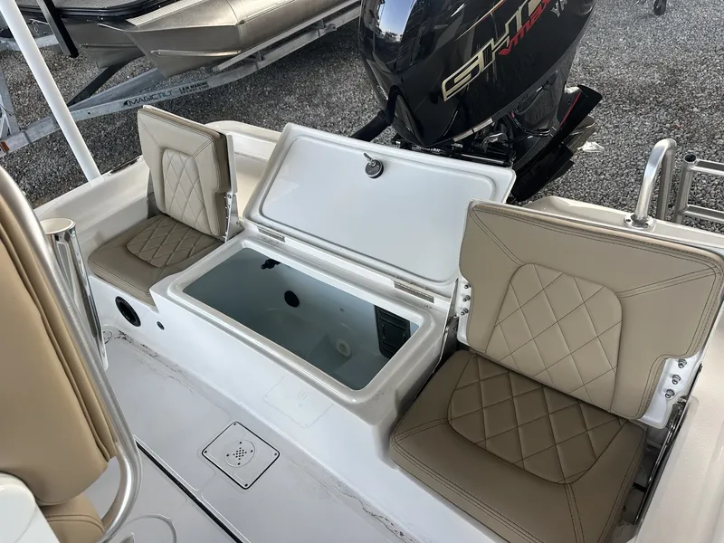 Slide: The Image of The image shows the seating area of a Blazer 2200 PURE BAY boat with beige upholstery and an engine. - 11