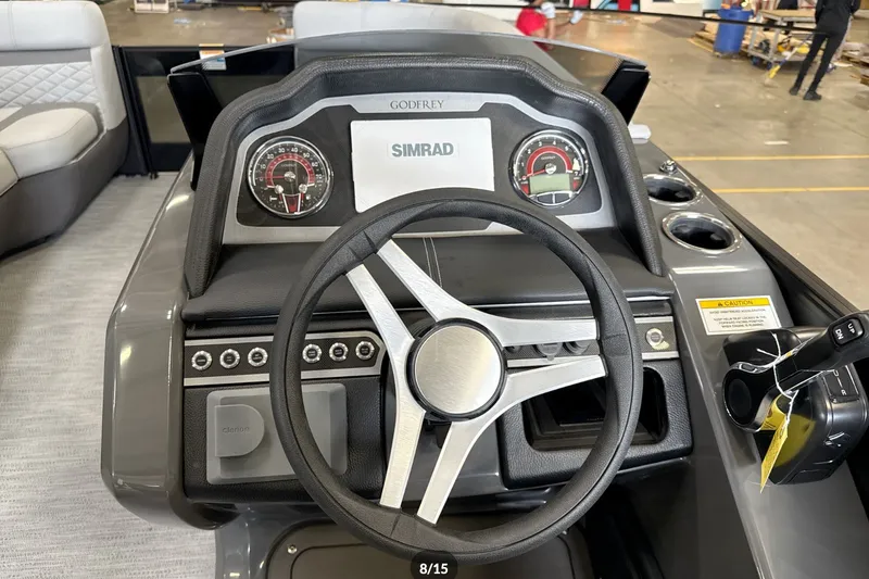 Slide: The Image of 2027 Godfrey Monaco 25' Tritoon dashboard with steering wheel and Simrad display. - 34