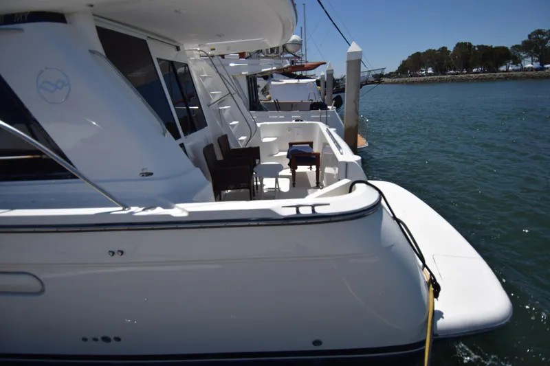 Slide: The Image of 1999 Bayliner 5288 Pilot House Motoryacht docked, featuring spacious deck and seating area. - 15