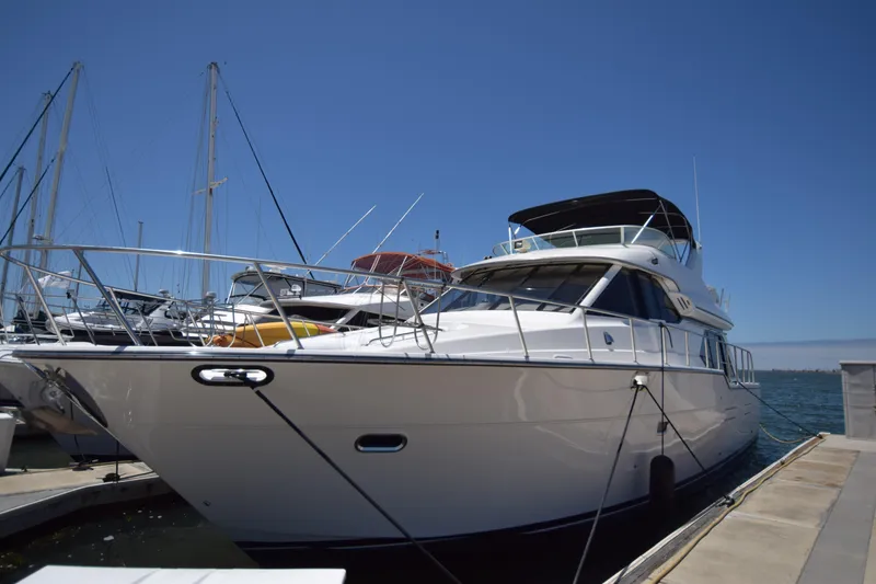 The Image of 1999 Bayliner 5288 Pilot House Motoryacht docked at marina under clear blue sky. - 0