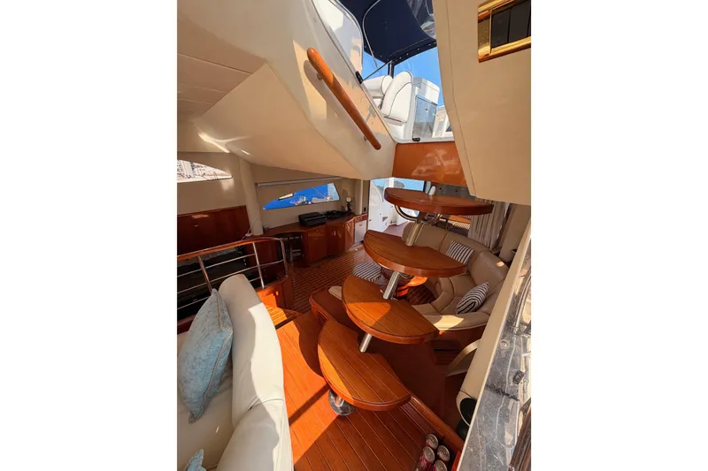 Slide: The Image of Luxurious interior of 2001 Fairline 55 yacht with elegant wooden finishes and plush seating. - 58