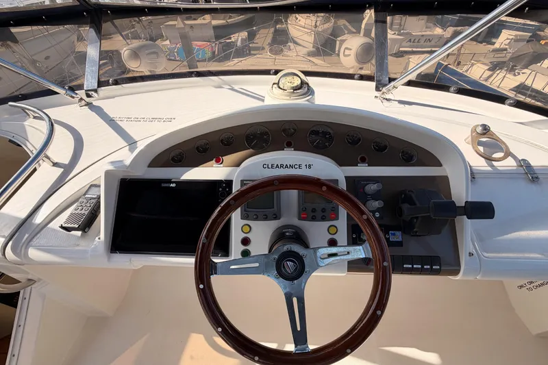 Slide: The Image of Cockpit of 2001 Fairline 55 yacht with steering wheel and navigation controls. - 71