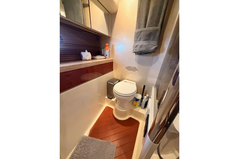 Slide: The Image of Bathroom interior of a 2001 Fairline 55 yacht, featuring modern amenities and wooden flooring. - 122