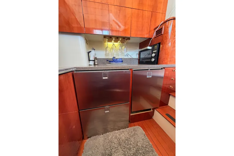 Slide: The Image of Luxurious galley kitchen in 2001 Fairline 55 yacht with modern appliances and wood cabinetry. - 39