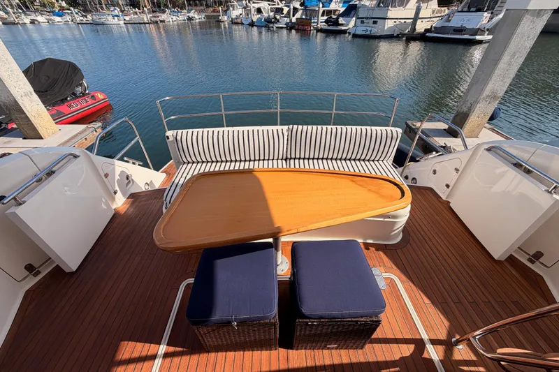 Slide: The Image of Luxury Fairline 55 yacht deck with seating, table, and marina view, 2001 model. - 134