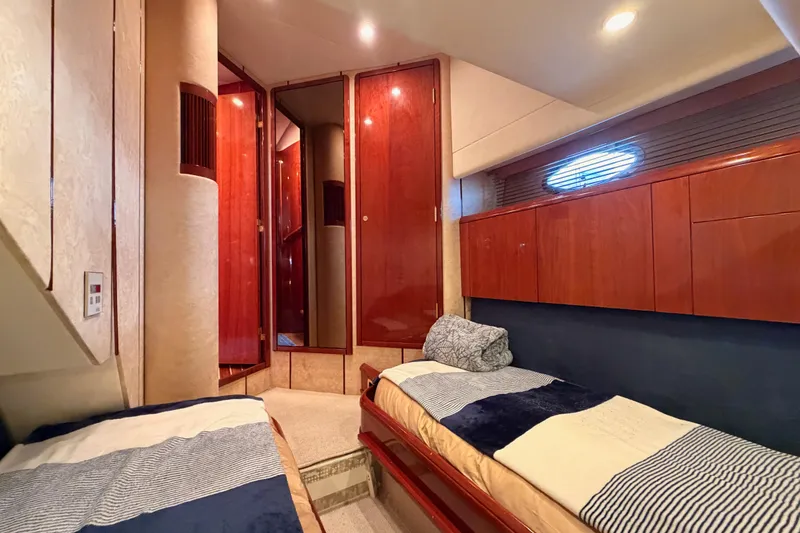 Slide: The Image of Luxurious cabin interior of 2001 Fairline 55 yacht with twin beds and wooden cabinetry. - 100