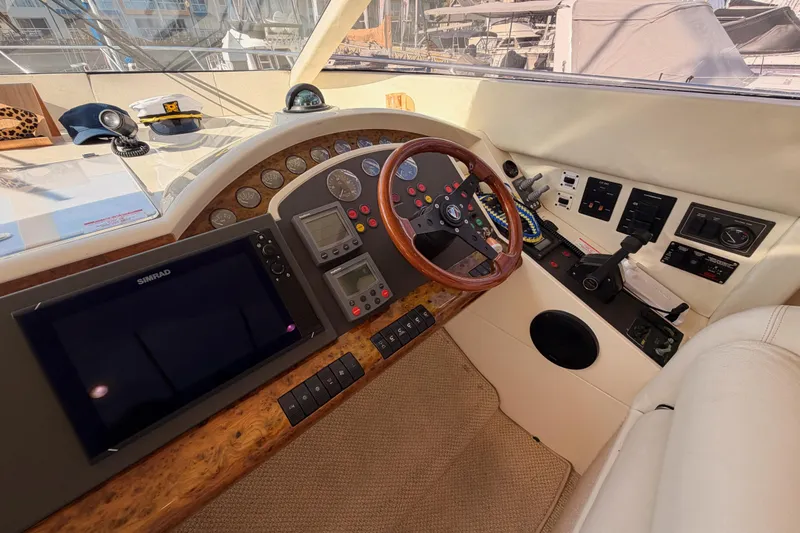 Slide: The Image of Cockpit of 2001 Fairline 55 yacht with navigation equipment and wooden steering wheel. - 82