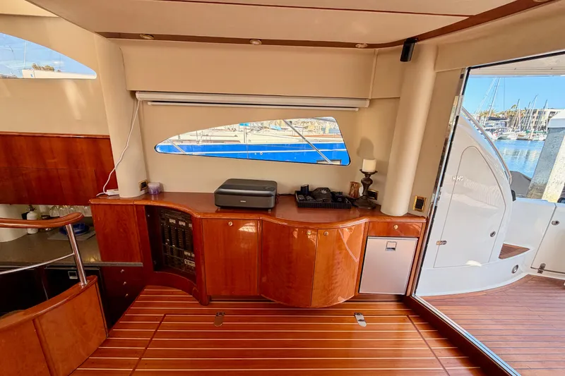 Slide: The Image of Luxurious interior of a 2001 Fairline 55 yacht with wooden cabinetry and marina view. - 24