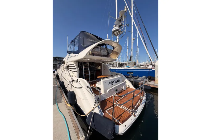 Slide: The Image of Luxury 2001 Fairline 55 yacht docked at marina, featuring sleek design and spacious deck. - 8