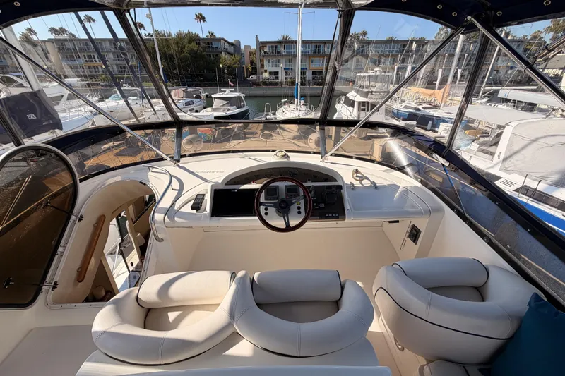 Slide: The Image of Cockpit view of a 2001 Fairline 55 yacht, featuring luxurious seating and marina backdrop. - 70