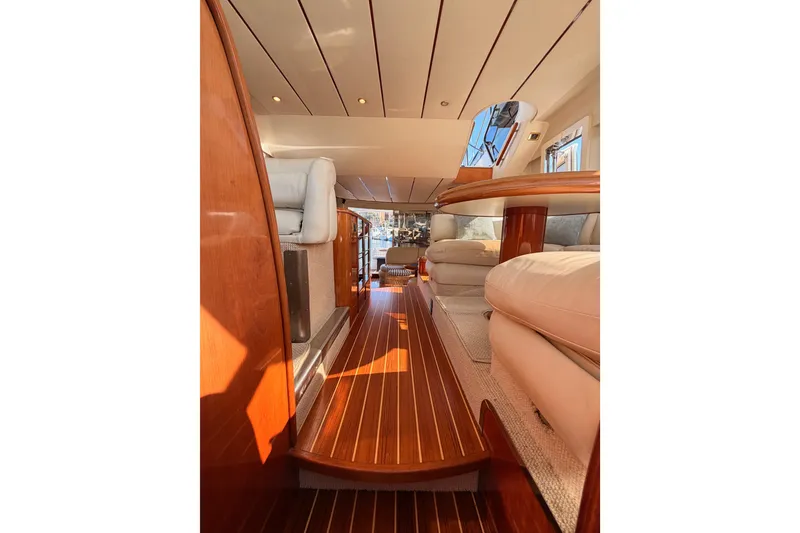 Slide: The Image of Luxurious interior of a 2001 Fairline 55 yacht with polished wood flooring and plush seating. - 127