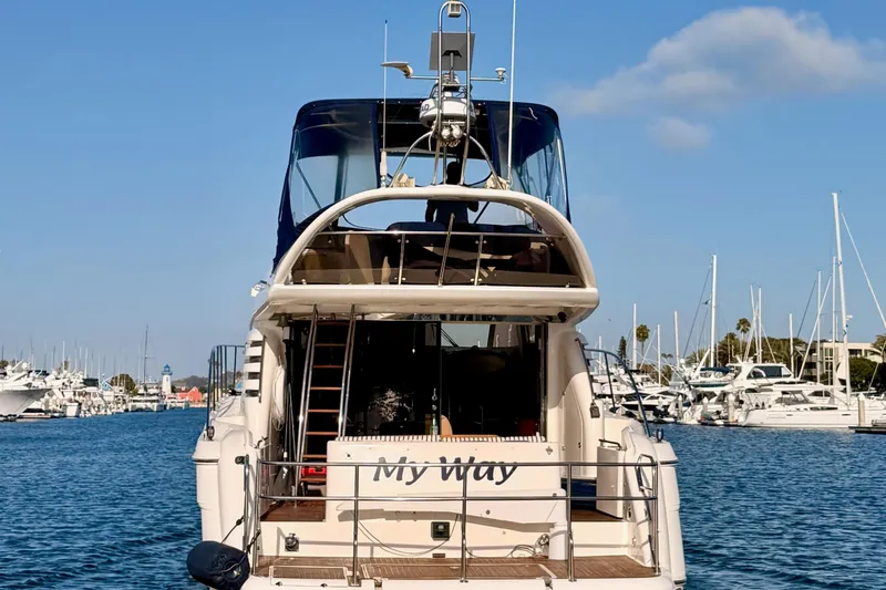Slide: The Image of Rear view of a 2001 Fairline 55 yacht named "My Way" docked in a marina. - 136