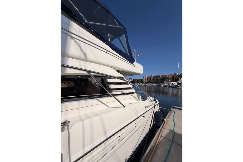 Slide: The Image of Luxury 2001 Fairline 55 yacht docked at marina under clear blue sky. - 7