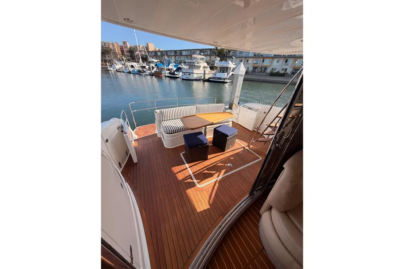 Slide: The Image of Outdoor deck of a 2001 Fairline 55 yacht with seating and table, docked at a marina. - 133