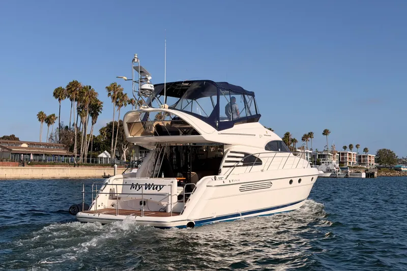 Slide: The Image of Luxury 2001 Fairline 55 yacht cruising near palm-lined shore. - 139