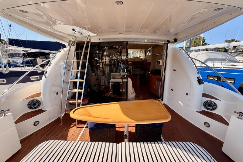 Slide: The Image of Luxurious 2001 Fairline 55 yacht interior with wooden deck and elegant seating area. - 14