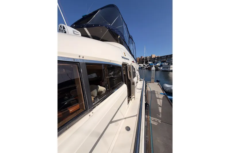 Slide: The Image of 2001 Fairline 55 yacht docked at marina, showcasing sleek design and spacious deck. - 56
