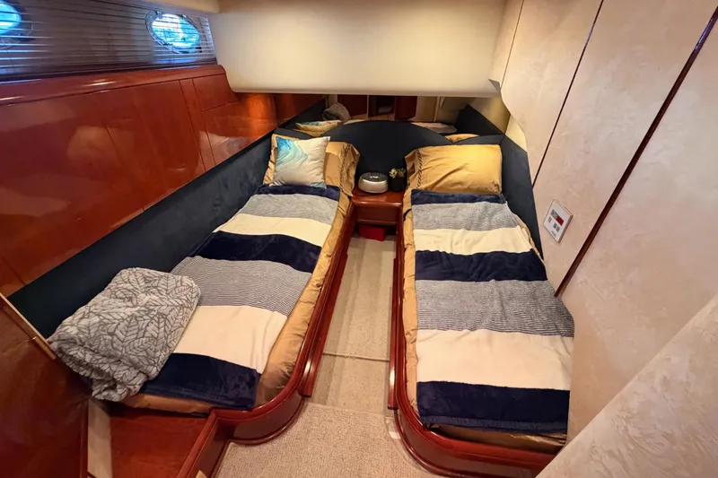 Slide: The Image of Luxurious twin cabin interior on a 2001 Fairline 55 yacht, featuring elegant bedding and wood finishes. - 98