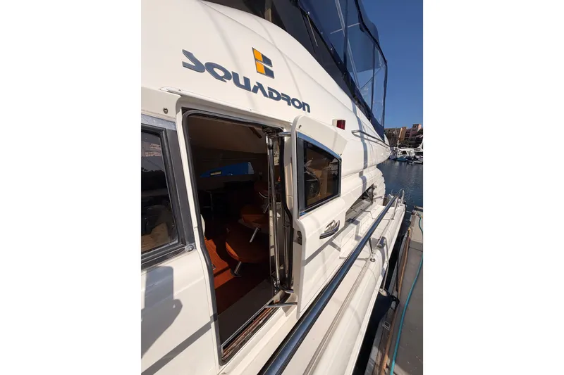 Slide: The Image of Fairline Squadron 55 yacht, 2001 model, docked with open cabin door, showcasing interior. - 57