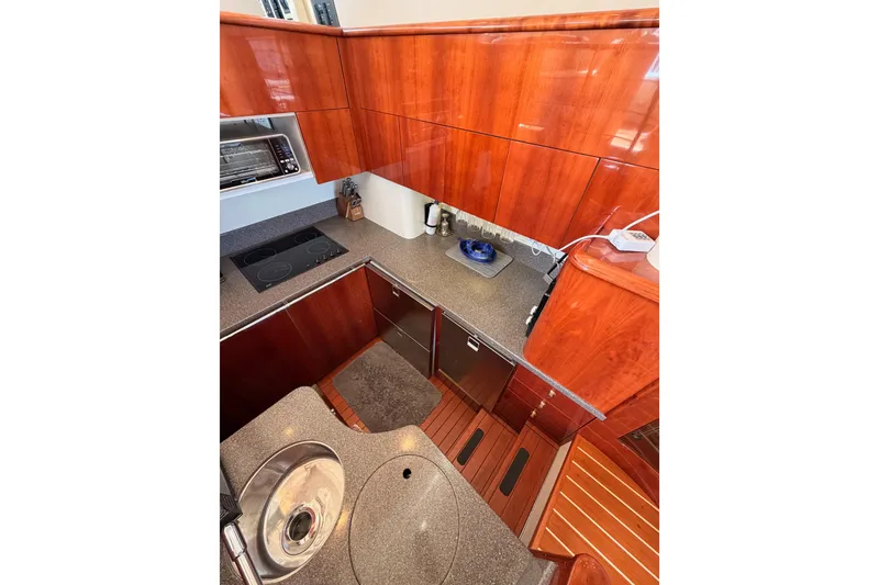 Slide: The Image of Luxurious galley kitchen in 2001 Fairline 55 yacht with wood cabinetry and modern appliances. - 29