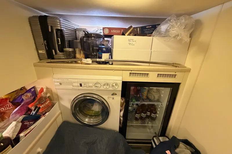 Slide: The Image of Laundry and storage area on a 2001 Fairline 55 yacht, featuring a washer and mini fridge. - 35