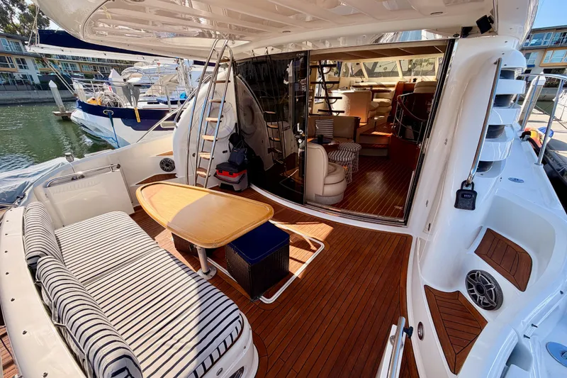 Slide: The Image of Luxury Fairline 55 yacht interior, featuring elegant seating and wooden deck, docked at marina. - 18
