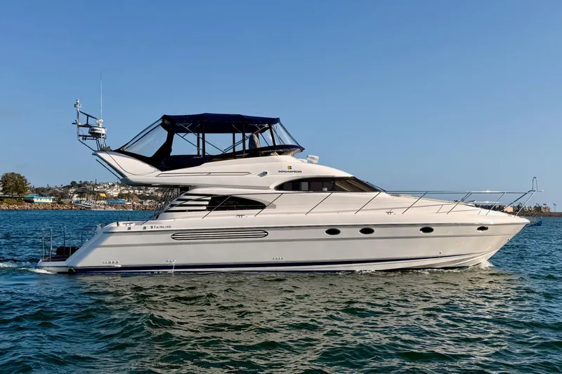 Slide: The Image of 2001 Fairline 55 yacht cruising on calm waters under a clear blue sky. - 140