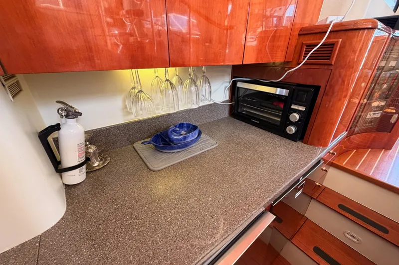 Slide: The Image of Kitchen area of a 2001 Fairline 55 yacht with countertop, toaster oven, and fire extinguisher. - 40