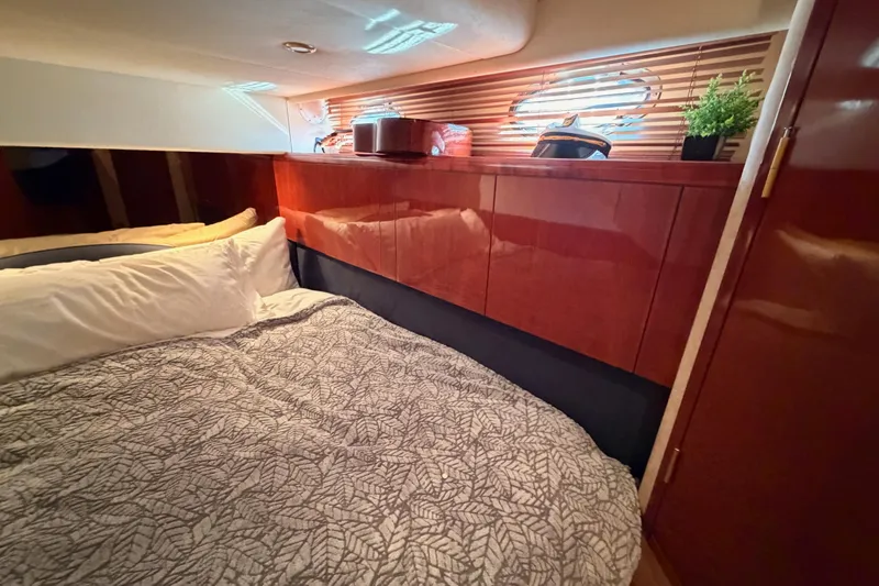 Slide: The Image of Luxurious cabin interior of a 2001 Fairline 55 yacht with cozy bedding and wooden accents. - 109