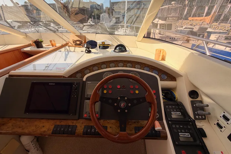 Slide: The Image of Cockpit of 2001 Fairline 55 yacht with steering wheel and navigation controls. - 90