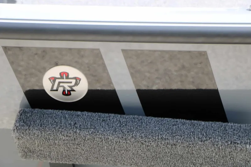 Slide: The Image of Close-up of a boat with gray carpeting and a round logo featuring a stylized 'R'. - 18