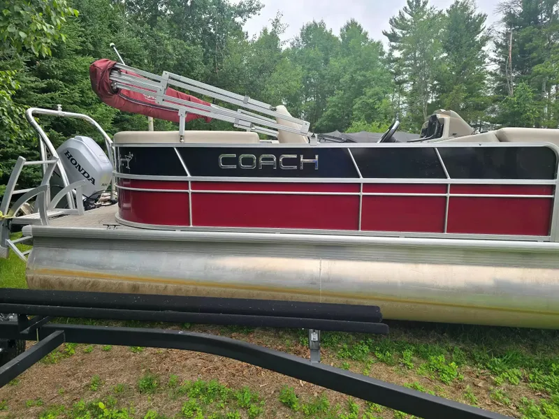 Slide: The Image of A red and black Coach pontoon boat, model 22RF, year 2019, is on a trailer. - 4