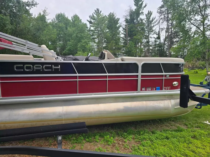 Slide: The Image of A red pontoon boat by Coach, model 22RF, year 2019, sits on a trailer in a grassy area. - 3