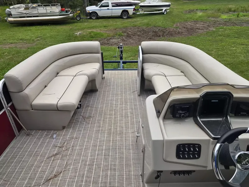 Slide: The Image of The image shows the interior of a pontoon boat with beige seating and a helm station. - 5