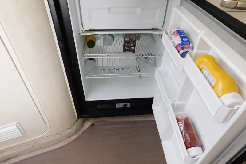 Slide: The Image of Open refrigerator in 1997 Sea Ray 330 Express Cruiser, stocked with condiments and beverages. - 73