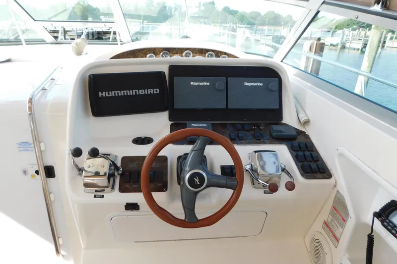 Slide: The Image of 1997 Sea Ray 330 Express Cruiser helm with navigation equipment and steering wheel. - 24