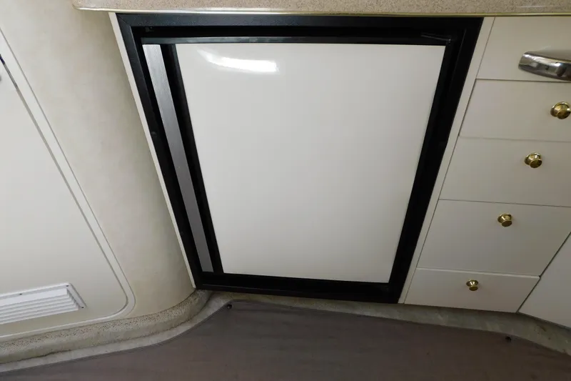 Slide: The Image of 1997 Sea Ray 330 Express Cruiser interior with compact refrigerator and storage drawers. - 72