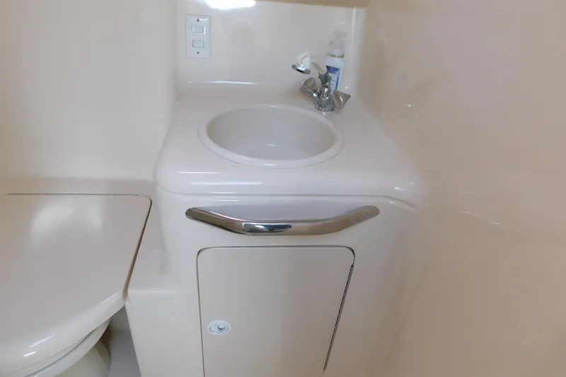 Slide: The Image of 1997 Sea Ray 330 Express Cruiser bathroom sink and toilet area. - 81