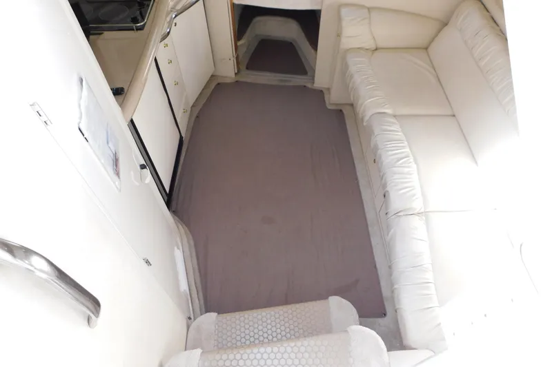 Slide: The Image of Interior of 1997 Sea Ray 330 Express Cruiser with white seating and compact kitchen area. - 44