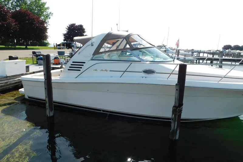 Slide: The Image of 1997 Sea Ray 330 Express Cruiser docked at a marina, showcasing sleek design and white exterior. - 3