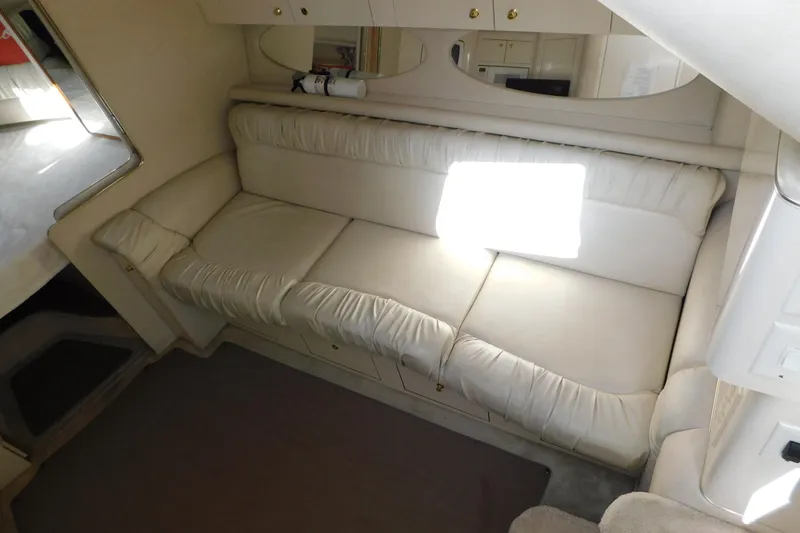 Slide: The Image of 1997 Sea Ray 330 Express Cruiser interior with cream leather seating and mirrored cabinets. - 45