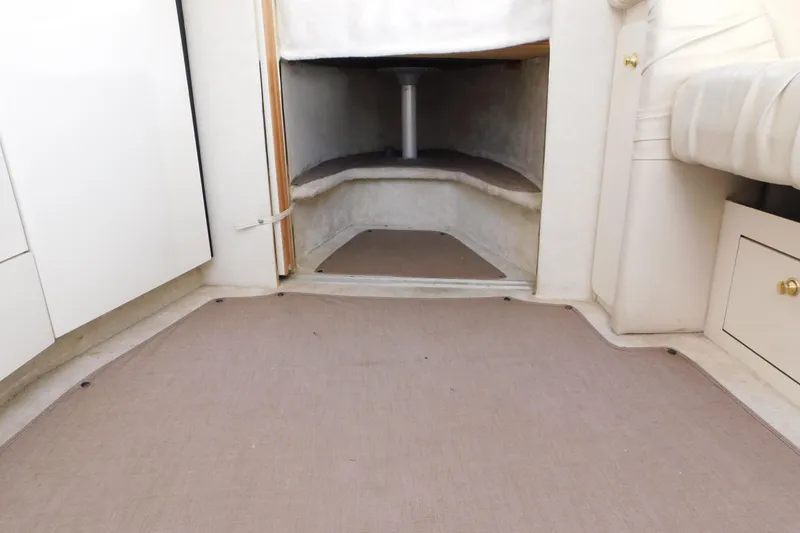 Slide: The Image of Interior cabin view of a 1997 Sea Ray 330 Express Cruiser, featuring beige carpeting and white cabinetry. - 64