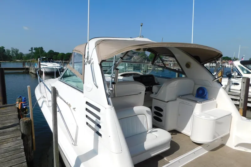 Slide: The Image of 1997 Sea Ray 330 Express Cruiser docked at marina, featuring spacious seating and sleek design. - 8