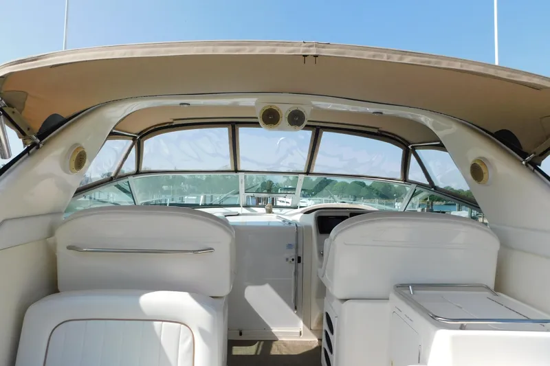 Slide: The Image of 1997 Sea Ray 330 Express Cruiser cockpit with white seating and clear windshield. - 42