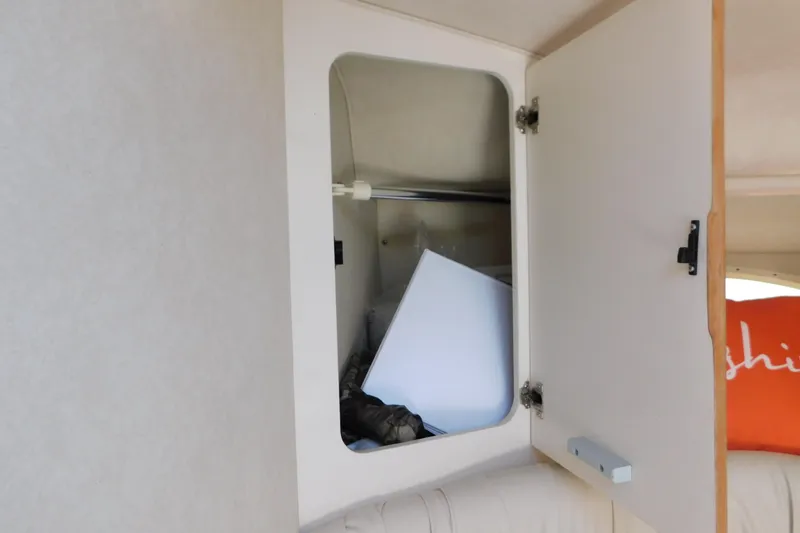 Slide: The Image of Open cabinet inside 1997 Sea Ray 330 Express Cruiser, showing storage space and items. - 62