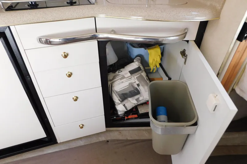 Slide: The Image of Interior of 1997 Sea Ray 330 Express Cruiser showing kitchen storage and trash bin. - 75