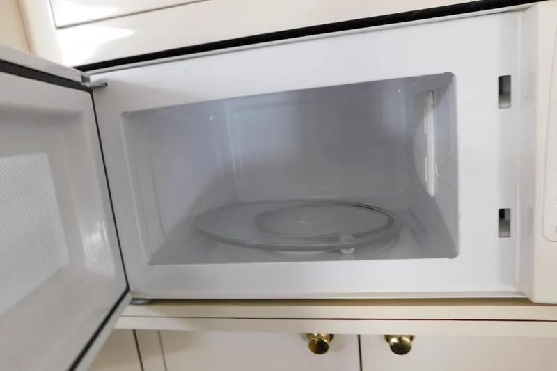 Slide: The Image of Open microwave oven with empty interior and glass turntable. - 68