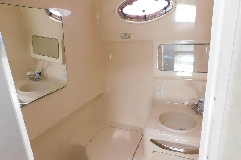 Slide: The Image of 1997 Sea Ray 330 Express Cruiser bathroom with sink, mirror, and porthole window. - 79