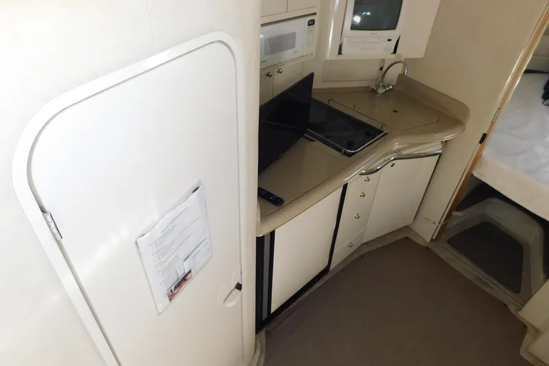 Slide: The Image of 1997 Sea Ray 330 Express Cruiser interior kitchen with stove, sink, and microwave. - 46